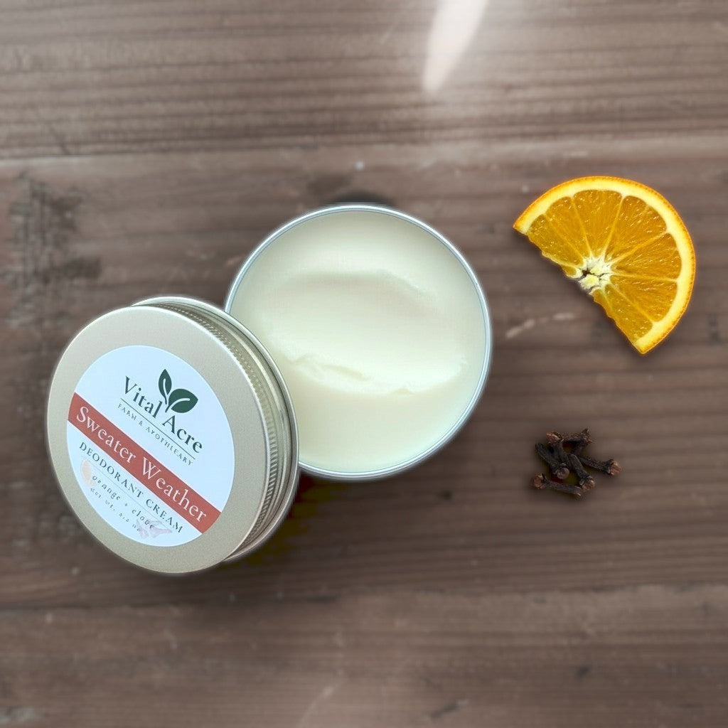 Vital Acre Farm & Apothecary Sweater Weather orange and clove natural deodorant cream in a metal tin on wood