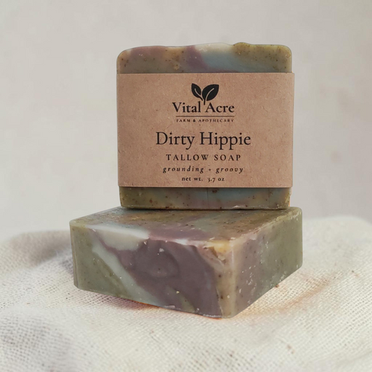 Vital Acre Farm & Apothecary Dirty Hippie tallow soap bar with earthy purple and green swirls on a stone surface.