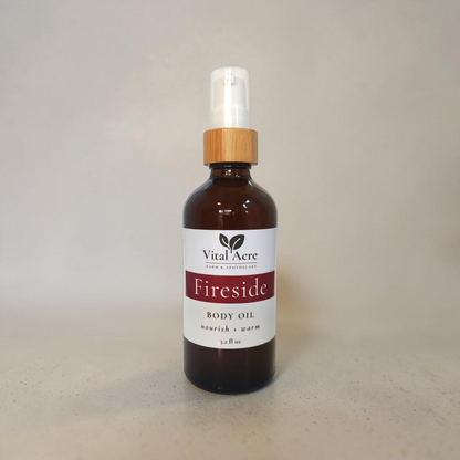 Vital Acre Farm & Apothecary Fireside nourishing body oil in an amber glass bottle with a bamboo pump dispenser.