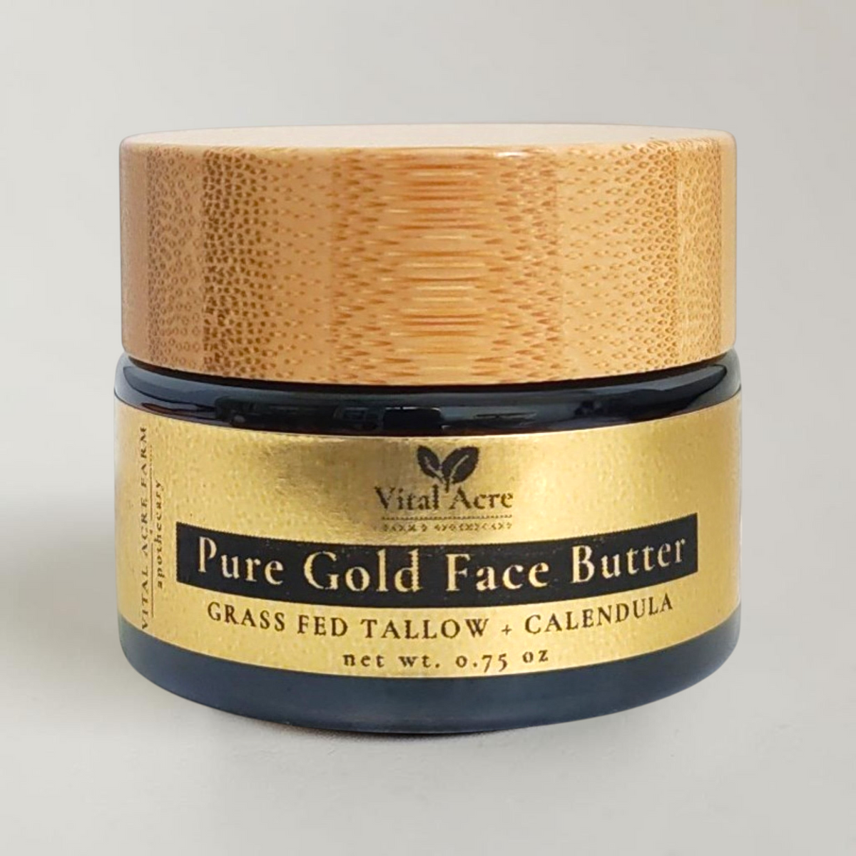 A jar of Vital Acre Pure Gold Face Butter with a light wood lid and a gold label, set against a plain light background.