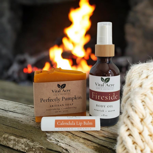 Vital Acre Farm & Apothecary Cozy Season Gift Set featuring pumpkin soap, Fireside body oil, and orange vanilla balm.