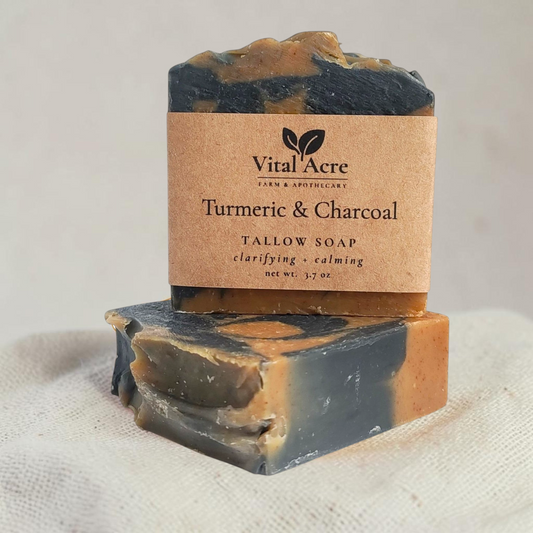 Vital Acre Farm & Apothecary turmeric and charcoal tallow soap bar with a rustic paper label on a white surface.